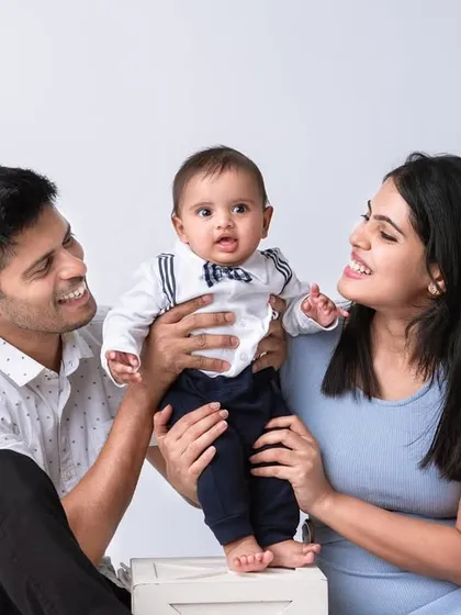 A different pose from the same studio shoot, this image shows the parents lifting their baby, creating a dynamic and interactive family portrait. My goal is to capture a range of poses, from calm and posed to energetic and playful.