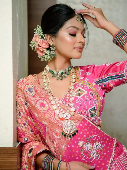 Wearing pink like a queen. This traditional Gujarati look is all about vibrant color, heavy jewelry, and a classic floral bun.