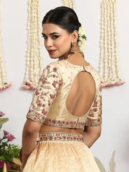 The back of this embroidered gold blouse features a keyhole design, adding a modern element to the traditional outfit.