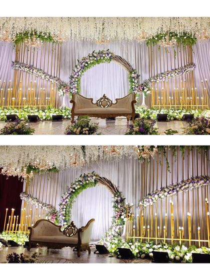 A stunning white and purple floral stage, featuring a large circular arch and cascading arrangements. The hanging wisteria ceiling and modern candle stands complete this elegant and dreamy look.