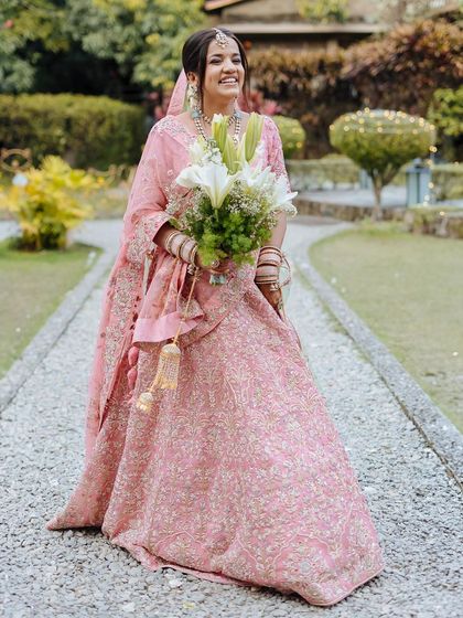 A joyful portrait of the bride, holding her bouquet and smiling, after her wedding ceremony.