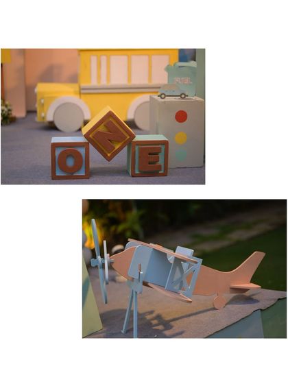 A collage of vehicle-themed props, including 'ONE' blocks, a school bus, and a vintage-style airplane.