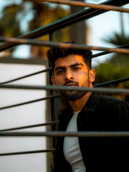 A creative portrait taken through a metal structure, adding layers and intrigue to the shot. This kind of artistic framing helps a model's portfolio stand out.