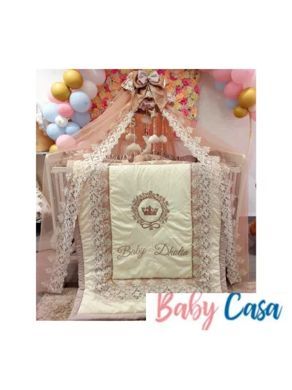 The full view of a magnificent royal nursery. This setup includes a personalized quilt, pillow bumpers, and a stunning lace-trimmed canopy, all tied together with a soft, elegant color scheme.