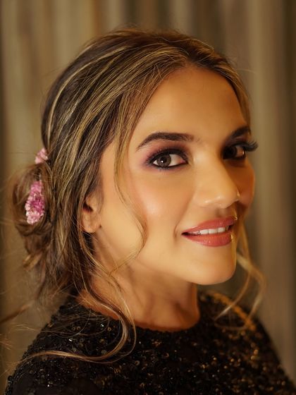 A smiling party look where the eyes do all the talking. The shimmering eyeshadow and defined lashes create a look that is both playful and glamorous.