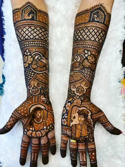 This design features portraits of the couple inside ornate frames on the palms. The arms are filled with beautiful peacock and floral patterns.