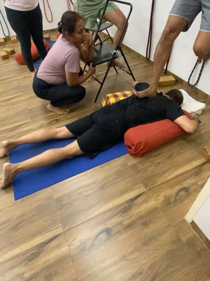 A hands-on adjustment to help a student release tension in the upper back. This direct feedback is a core part of my teaching method.