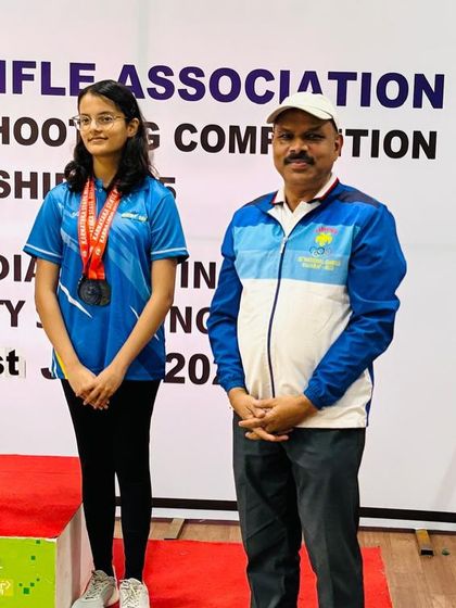 A moment of pride as our shooter stands on the podium next to me after winning a medal in the air rifle event.