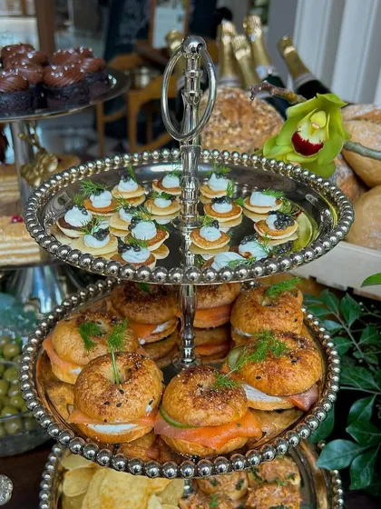 A three-tiered silver stand laden with smoked salmon bagels and caviar blinis, classic brunch favorites executed to perfection.