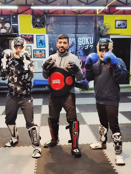 A coach with two of his students in full sparring gear. We are here to guide you every step of the way.