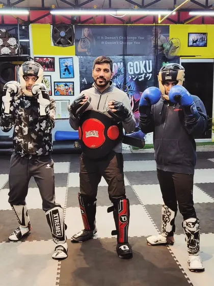A coach with two of his students in full sparring gear. We are here to guide you every step of the way.