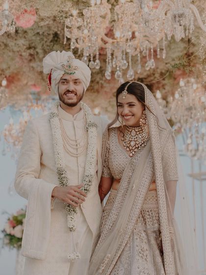 A happy, candid moment of the newlyweds. Their genuine smiles and relaxed posture show the joy and relief of being officially married, surrounded by the beauty of their wedding decor.