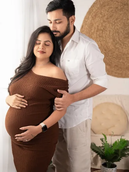 A tender moment by the window. The soft natural light and the gentle embrace make this a beautiful and classic pregnancy portrait.