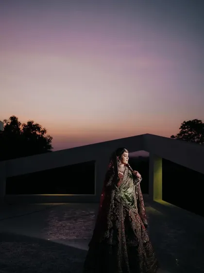 An artistic shot of the bride against the evening sky, using dramatic lighting to create a powerful and memorable bridal portrait.
