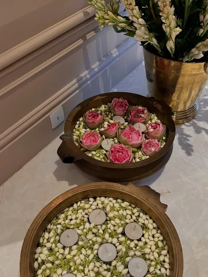 A closer look at the brass urlis. The combination of water, flowers, and floating candles is a traditional way to welcome guests and bring positive energy into a home.