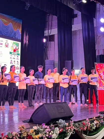 A group photo of our student performers on stage. These events build confidence and create lasting memories for our yoga community.