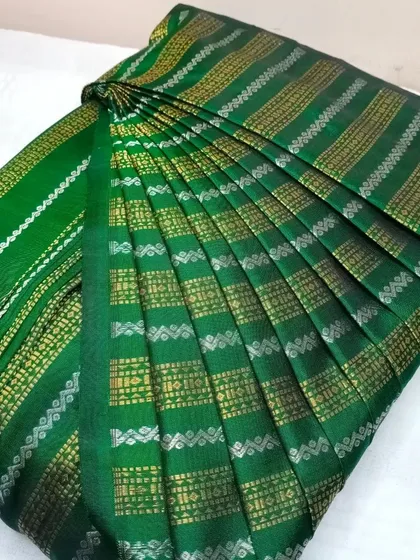 A dark green silk saree with intricate silver and gold stripes.