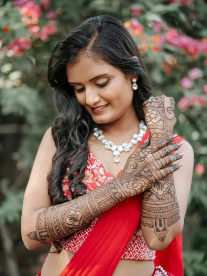Seeing my brides happy is the best part of my work. Here is a beautiful bride showing off her full-arm traditional mehendi, with the rich henna color complementing her engagement attire perfectly.