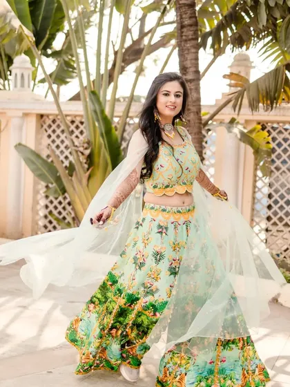 A joyful shot of the bride twirling in her beautiful lehenga. Her mehndi is a stunning accessory that adds to the magic of the moment.