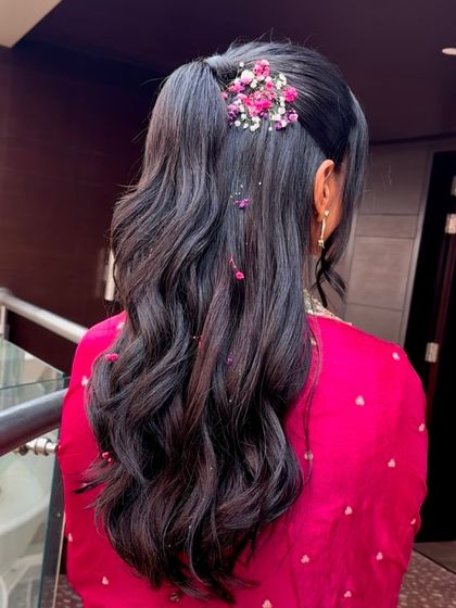 Another view of the floral half-up ponytail, showing how the soft waves cascade down the back. This is a youthful and fresh hairstyle for any daytime event.