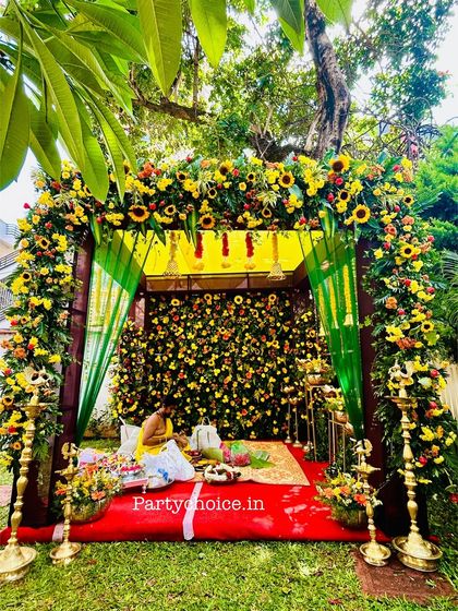A priest performing rituals within the stunning sunflower and marigold mandap we created for an outdoor ceremony.
