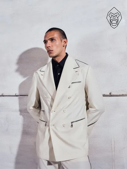 A full look of the Ivory Industrial suit. The double-breasted silhouette is given a contemporary update with sharp contrast piping and bold hardware, creating a look of polished presence.