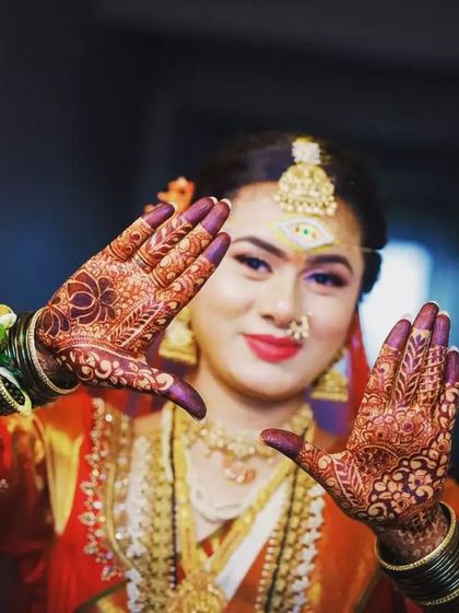 A beautiful bride framing her face with her henna-covered hands. The deep, rich stain of the organic henna looks stunning in her wedding photos.