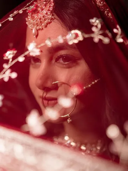 A bridal portrait is about capturing a feeling. Here, I focused on an intimate close-up, highlighting the delicate embroidery on the red veil and the traditional nath jewelry, creating a timeless and emotional shot for the bride.