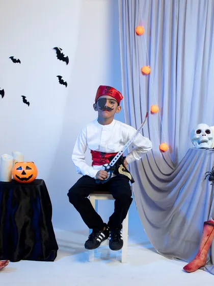 A child dressed as a pirate with an eye patch and sword for Halloween.