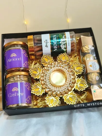 A classic and elegant choice for corporate gifting. This hamper features two jars of premium almonds and cashews, Ferrero Rocher chocolates, mogra-scented incense sticks, and a stunning lotus diya holder, all packed in a sleek black box.