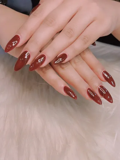 A deep, vampy maroon on long stiletto nails. This color is dramatic, sophisticated, and perfect for the autumn and winter months.