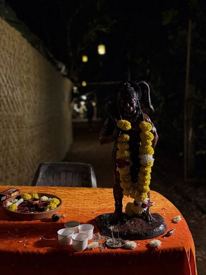A nighttime puja (ritual) setup. The practice of yoga is deeply interwoven with Indian rituals that honor the divine, like this offering to Hanuman, symbolizing devotion and strength.