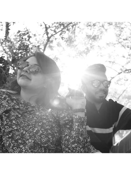 A sun-drenched black-and-white photo of a couple enjoying a bright day outdoors, capturing a candid and happy moment.