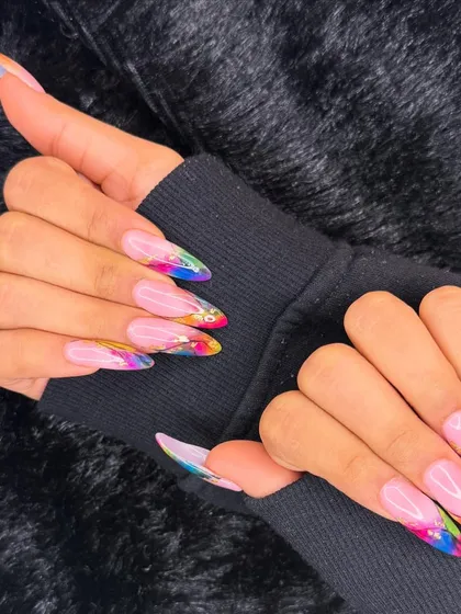 A long and dramatic set with a splash of color. This design features a sheer pink base with vibrant, rainbow-colored abstract art at the tips.