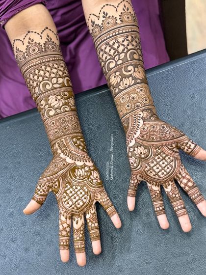 This bridal design showcases flowing, symmetrical patterns that extend up the arms, creating a graceful and elegant look.