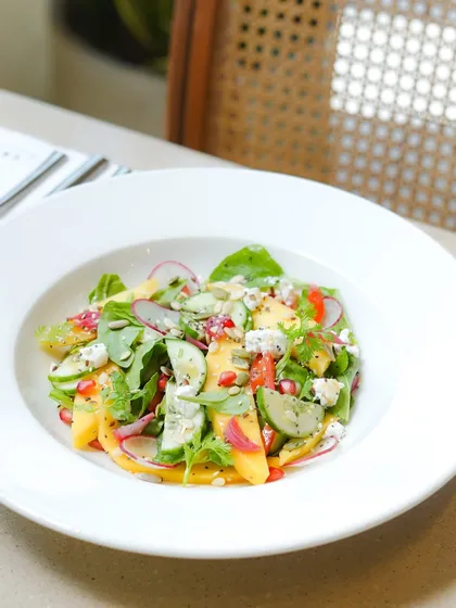 Our summer menu is all about eating what's in season. This baby spinach and Alphonso mango salad is a perfect example, combining sweet mango with fresh greens, cucumber, and feta.