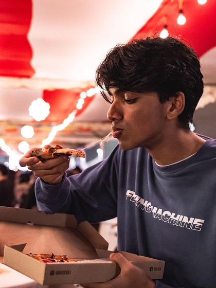 That cheese pull is a sign of a great pizza. A young guest enjoys a slice straight from the box at one of our event stalls.