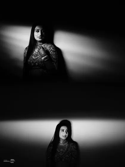 An artistic, high-contrast black and white bridal portrait. The dramatic play of light and shadow creates a moody, cinematic, and powerful image.