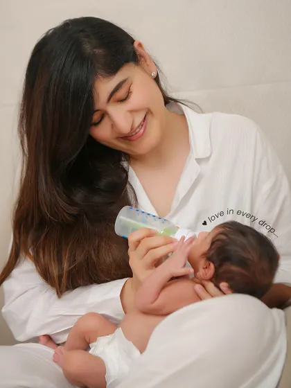 Even feeding time is a beautiful memory to capture. This candid shot shows a mother lovingly feeding her baby, a real and tender moment of care.