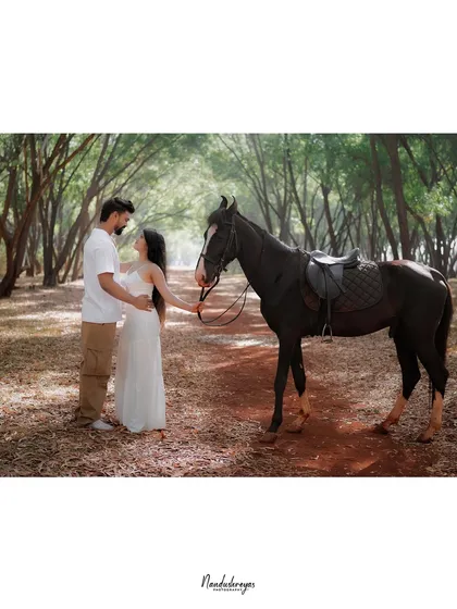 A beautifully framed shot of a couple and a horse in the woods, with a classic, timeless feel.