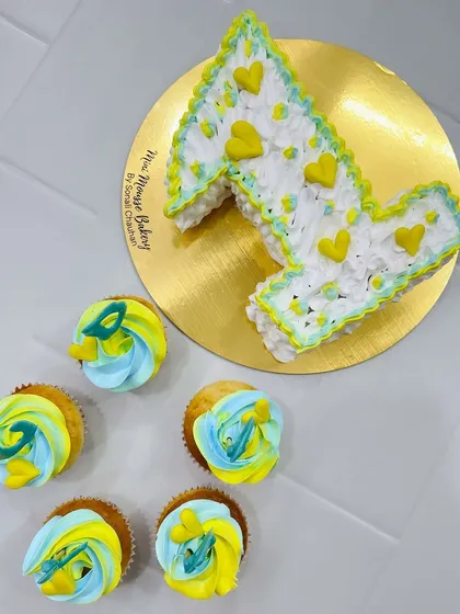 A custom monogram cake I made for a first birthday celebration. The "A" shaped cake is paired with matching cupcakes in a fun yellow and blue theme.
