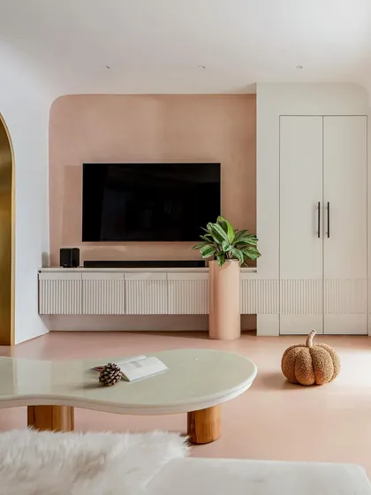 The family lounge serves as a calm sanctuary and a transition to the private spaces. The TV unit cleverly conceals the entrance to a bedroom.