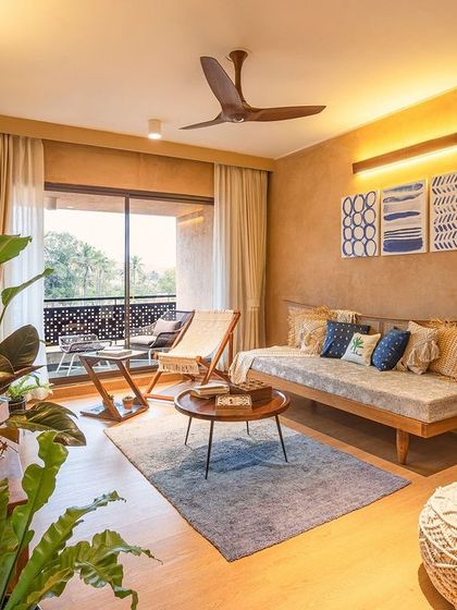 This informal lounge space opens onto a private balcony, offering a perfect spot for morning coffee. The furniture is light and airy, with a woven daybed and natural fiber rug that reinforce the villa's connection to organic materials and textures.