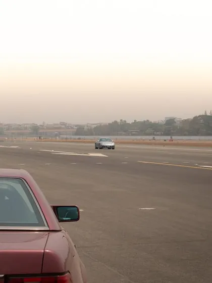 A simple, contemplative shot from behind a classic Mercedes, looking down the long stretch of runway ahead.
