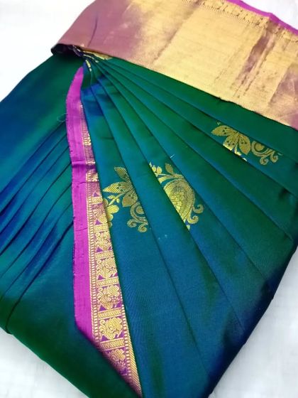 A deep green saree with a pink border and gold motifs. The pleats are set, and the saree is ready to be draped in under five minutes.