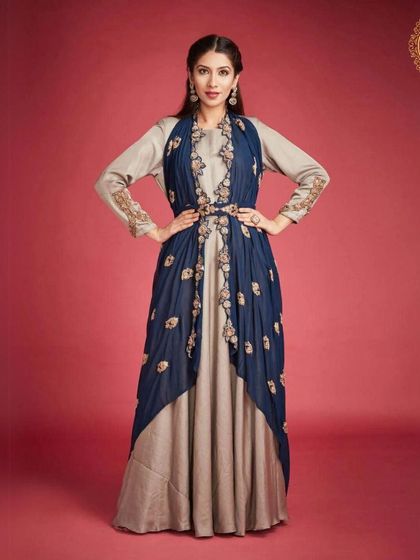 This beige and navy blue gown with an attached embroidered jacket is a sophisticated Indo-western option. It's perfect for a formal reception or card party.