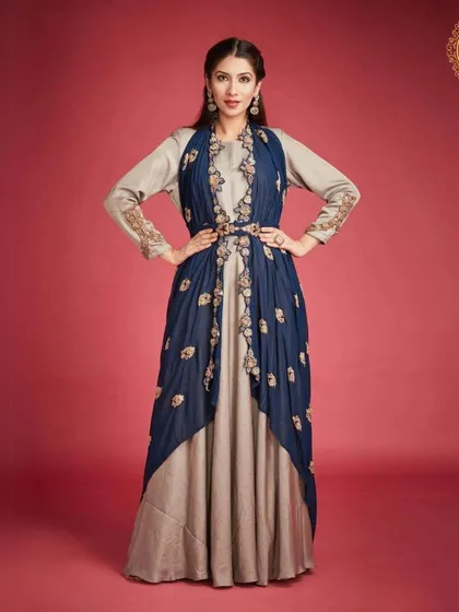 This beige and navy blue gown with an attached embroidered jacket is a sophisticated Indo-western option. It's perfect for a formal reception or card party.