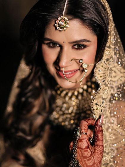A stunning bridal portrait with soft waves peeking from under the veil.
