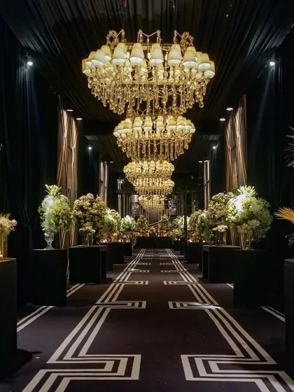 Personal stories are at the heart of my designs. For this anniversary, I created a 'memory lane' entrance, lining the grand, chandelier-lit hall with framed photos that told the couple's 25-year love story, making the celebration deeply personal and touching.