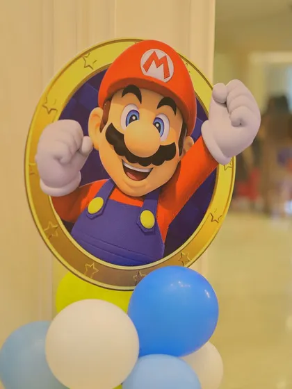 A close-up of a Super Mario character cutout placed on a balloon cluster. This is a simple yet effective way to distribute the theme throughout the party space.